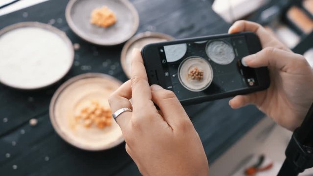 Female hands take photos of indian food by smartphone. Closeup. 4K.