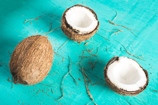 Half and whole coconut on a blue background with peel
