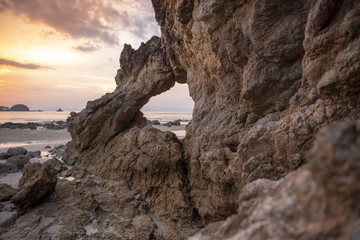Beautiful rock on beach at sunset