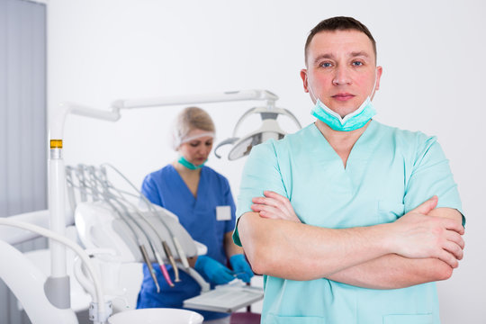 Male dentist with arms crossed in dental office