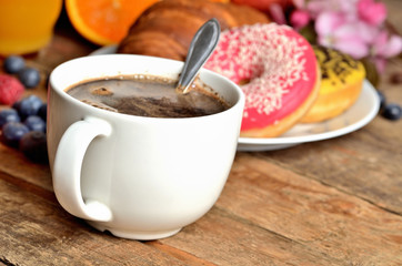 Mug with Turkish coffee, croissant, donuts, fresh fruit - grapes, orange and juice - breakfast