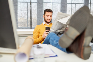 Mann liest Zeitung und trinkt Kaffee