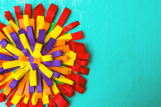 Children's handmade from colored paper -  colourful flower on blue background