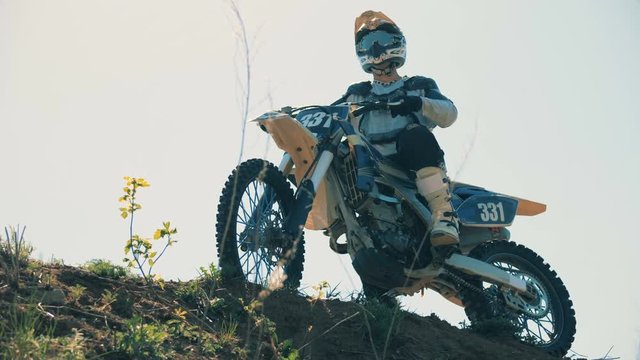 Autobike with a rider on it is standing on a hill