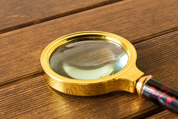 Magnifying glass on wooden table. Search concept