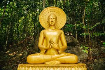Statue of a golden buddha woman in a forest. Buddhism, religion.