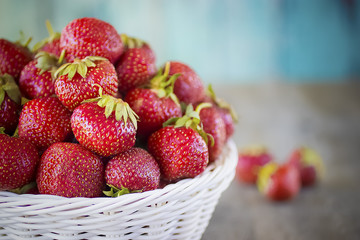 Ripe strawberries in white basket  on  gray background.