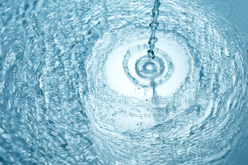 Background of blue clear water in motion with waves, pouring with splash