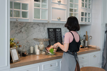 young women are cooking in the kitchen, family activities, Healthy food at home. Happy woman is preparing the vegetables and fruit in the kitchen.