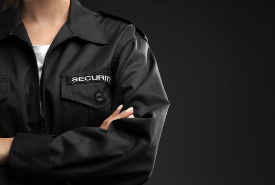 Female security guard in uniform on dark background, closeup