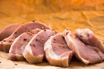 Fresh raw pork chops on a cutting board.  Arrangement  on the wrapping paper