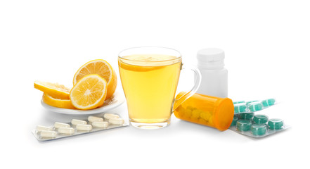Hot tea with lemon, pills and drugs for cold on white background