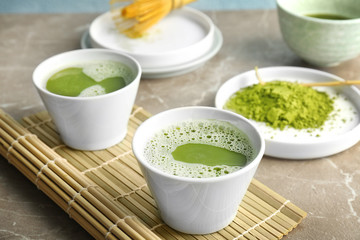 Fresh matcha tea and bamboo mat on table