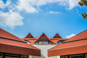 colorful exterior facade of house roof with summer blue sky clouds