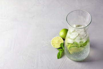 Natural lemonade with lime in jug on grey background
