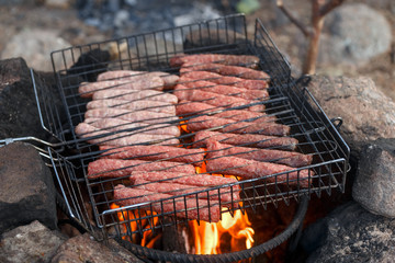 Sausage fire-roasted on the grill. Picnic in nature