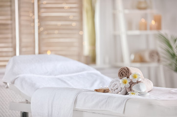 Towels and candles on massage table in modern spa salon. Place for relaxation