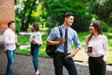 Two young Students talking in front of friends in the University in campus