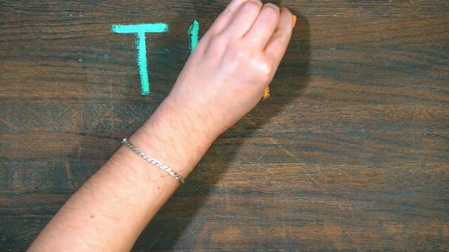 Closeup of hand draws on a wooden board. Smile and inscription with chalk. the end