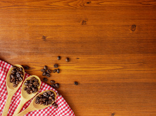 Flat lay,top view coffee beans in wooden spoons and on wooden table with copy space