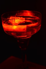 In a glass of champagne floating red ice cube is very stylish and beautiful