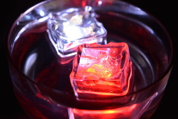 In a glass of champagne floating a white ice cube and a red ice cube and very bright and romantic