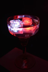 In a glass of champagne floating a white ice cube and a red ice cube and very bright and romantic