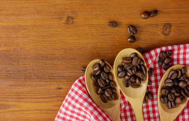 Flat lay,top view coffee beans in wooden spoons and on wooden table with copy space