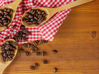 Flat lay,top view coffee beans in wooden spoons and on wooden table with copy space