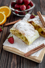 Homemade strudel with apples on a wooden background
