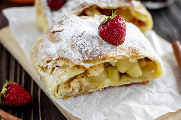 Homemade strudel with apples on a wooden background
