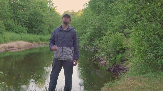 Mosquitoes attack.. Male Traveler Using Mosquito Spray near forest river. Repellent Protection