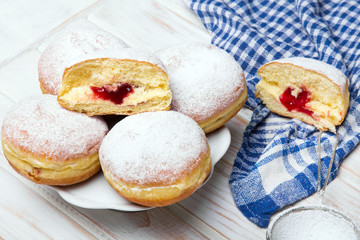 Traditional Polish donuts on wooden background.  Tasty doughnuts with jam.