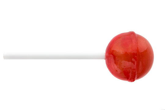 Lollipop on a stick on a white background. Round candy of red color on a white background.