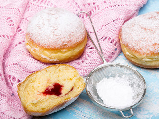 Traditional Polish donuts on wooden background.  Tasty doughnuts with jam.