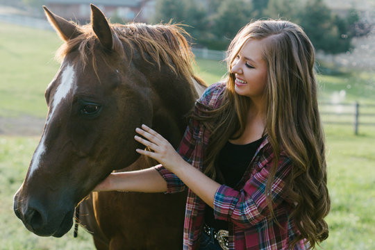 teenager giving attention to her horse