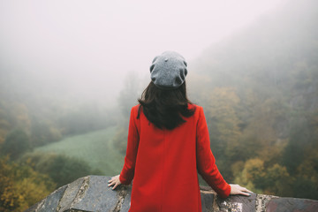 Back view of a young woman wearing red coat