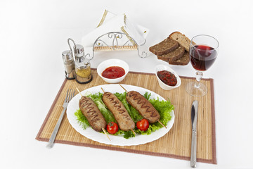 Lula kebab with tomatoes and cucumbers. Serve with black or white bread and a glass of red wine.