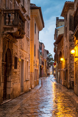 Fototapeta premium Street in Porec town illuminated by lamps at the evening, Croatia, Europe.