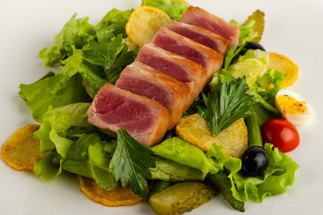 Salad with smoked fish close-up and vegetables on a white background