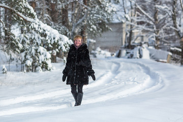 Fototapeta na wymiar Woman in the snowy russian village at winter.