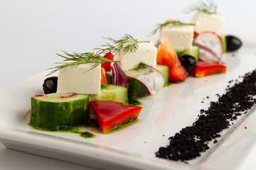 Greek salad in white salad bowl on a white background Close-up