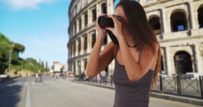 Beautiful young tourist woman standing near the Roman Coliseum taking picture with dslr camera, Travel photographer in Rome, Italy taking street photo, 4k