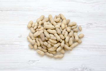 Peanuts in a shell on a white wooden background, top view.
