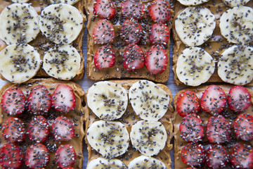 Healthy breakfast, dieting concept. Vegan toasts with fruits, seeds, peanut butter, close-up.