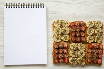 Vegan toasts with notepad on white wooden background, top view. Clean eating concept. From above. Flat lay.