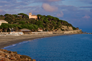 Obraz premium sunny beach with a pine forest on the hill behind it. Liguria, Italy