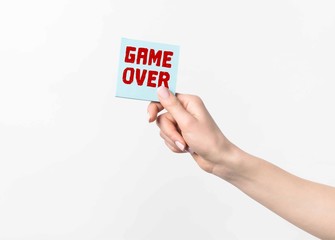 cropped shot of woman holding blue sticky note with Game over lettering, isolated n white