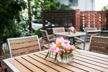 Patio  with pink flowers sitting on outdoor tables