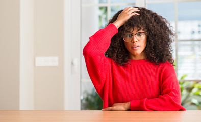 Fototapeta na wymiar African american woman wearing glasses stressed with hand on head, shocked with shame and surprise face, angry and frustrated. Fear and upset for mistake.